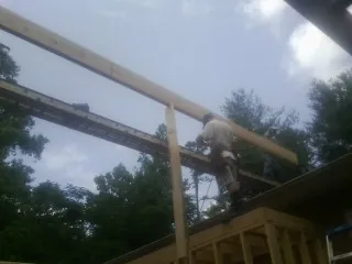 Carpenter setting a ridge beam over a new addition frame — Ice Dam Removal by Roofing Brothers in San Marcos