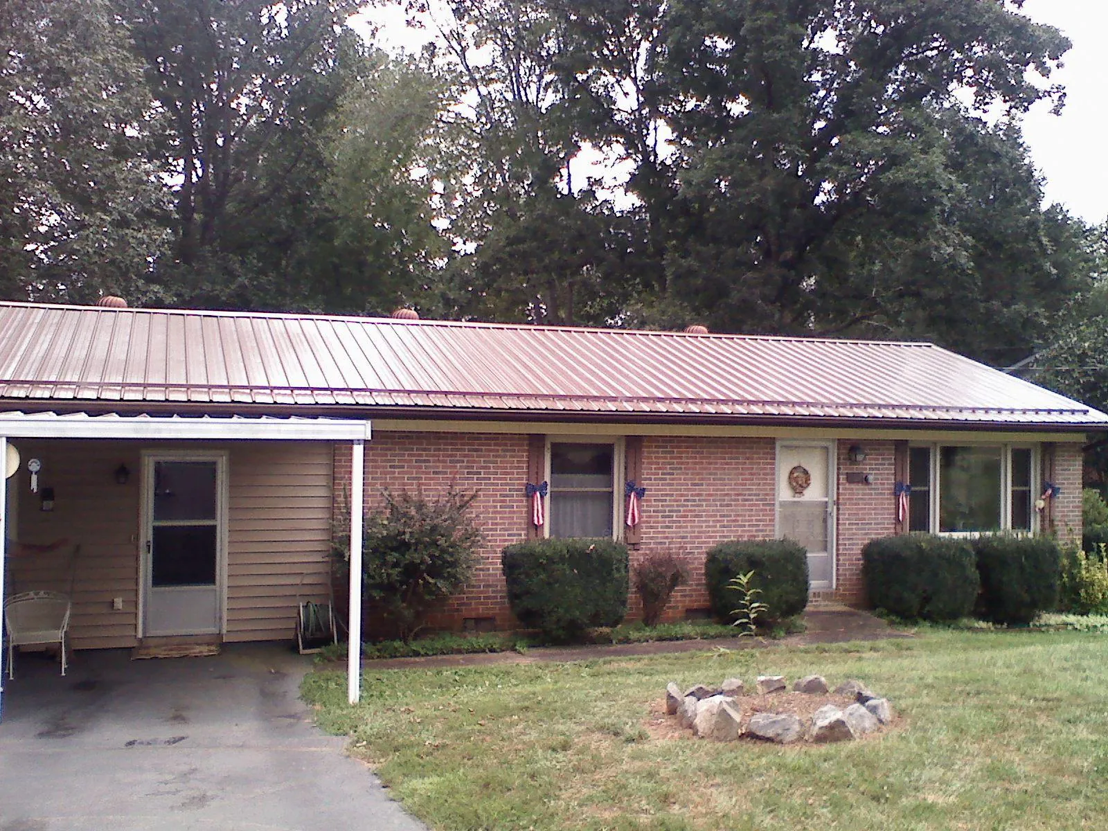 Bronze metal roof and carport on a brick ranch home — Roof Repair work by our crew in San Marcos